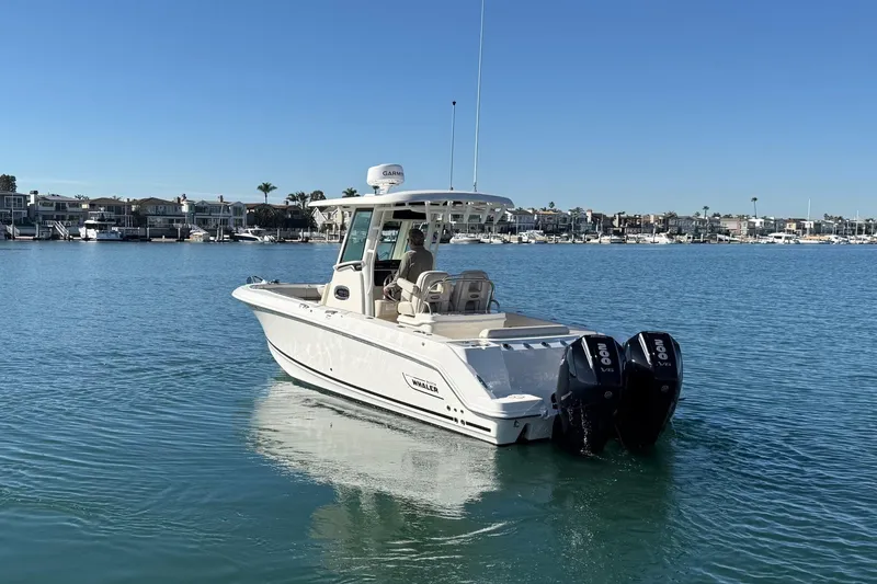 Slide: The Image of 2025 Boston Whaler 250 Outrage boat on calm water, featuring dual engines. - 5