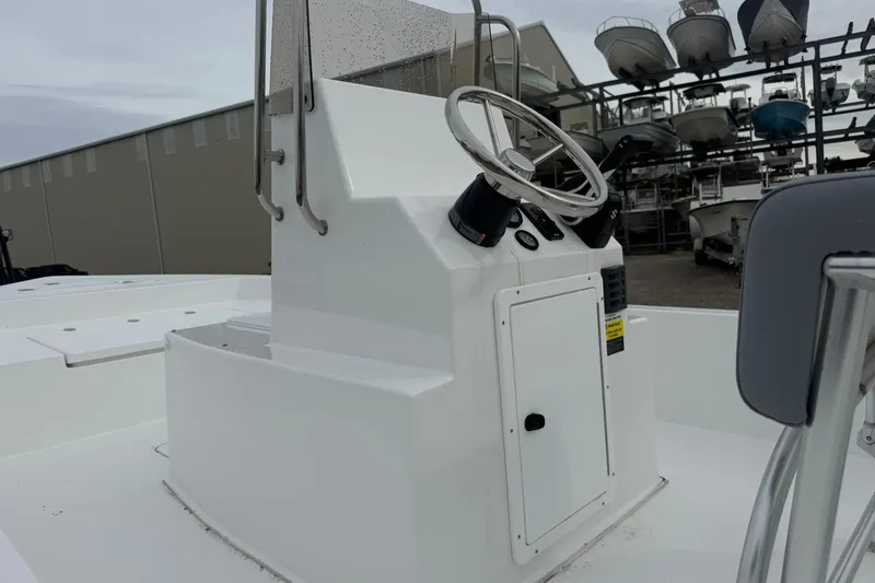 Slide: The Image of Center console of a 2026 Lookout Bay 19 boat, featuring steering wheel and controls. - 7
