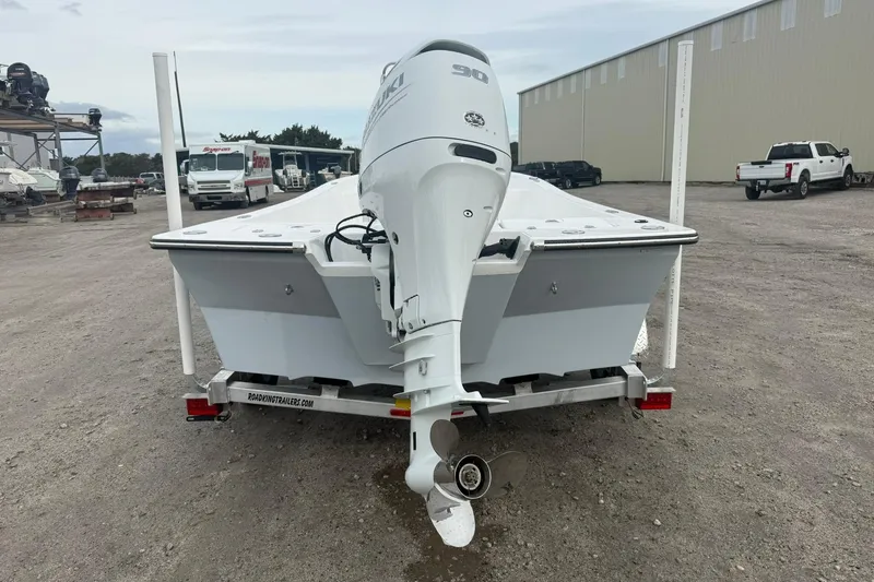 Slide: The Image of 2026 Lookout Bay 19 boat on trailer with outboard motor in a parking area. - 9