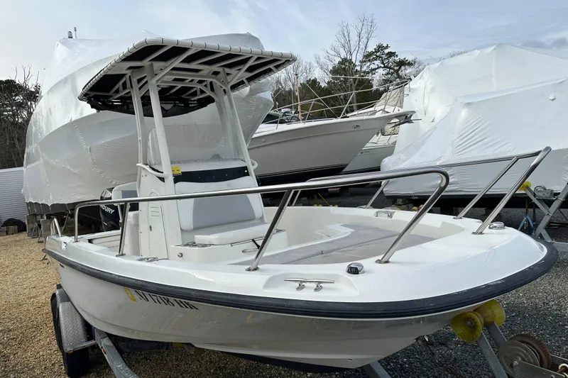Slide: The Image of 2016 Boston Whaler 210 Dauntless boat on trailer, parked outdoors. - 2