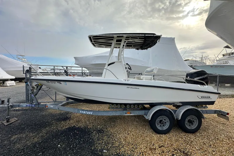 Slide: The Image of 2016 Boston Whaler 210 Dauntless boat in storage, surrounded by other vessels. - 23