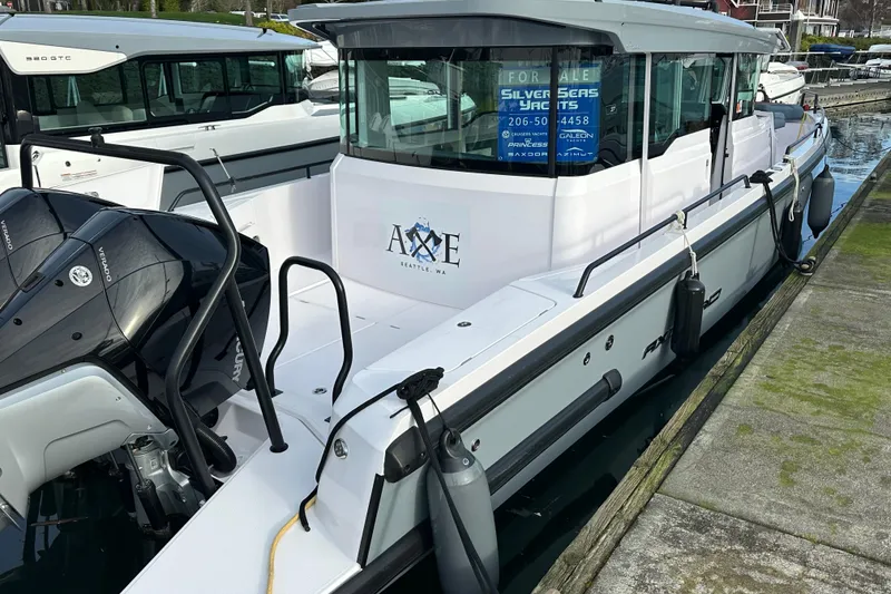 Slide: The Image of 2022 Axopar 37 XC Cross Cabin boat docked, featuring sleek design and powerful engines. - 1