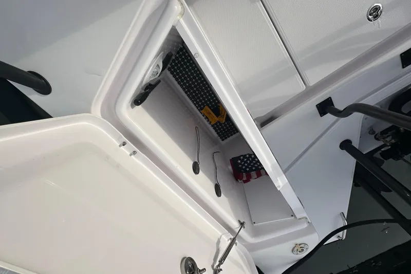 Slide: The Image of Storage compartment on a 2022 Axopar 37 XC Cross Cabin boat, featuring an American flag. - 11