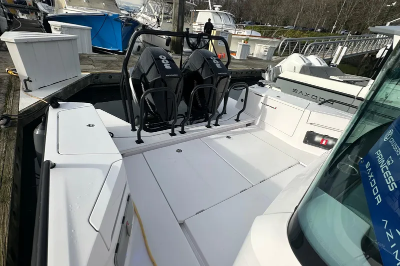 Slide: The Image of 2022 Axopar 37 XC Cross Cabin docked, showcasing dual outboard engines and spacious deck. - 14