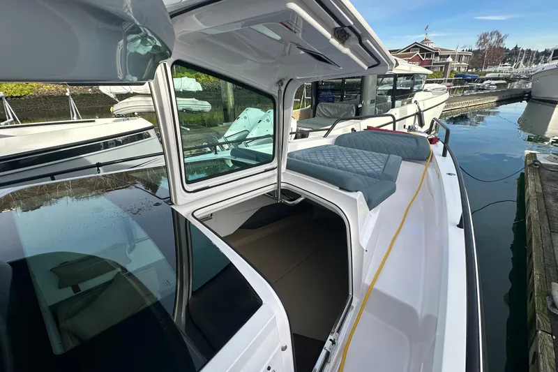 Slide: The Image of 2022 Axopar 37 XC Cross Cabin boat docked, featuring open cabin and cushioned seating. - 17