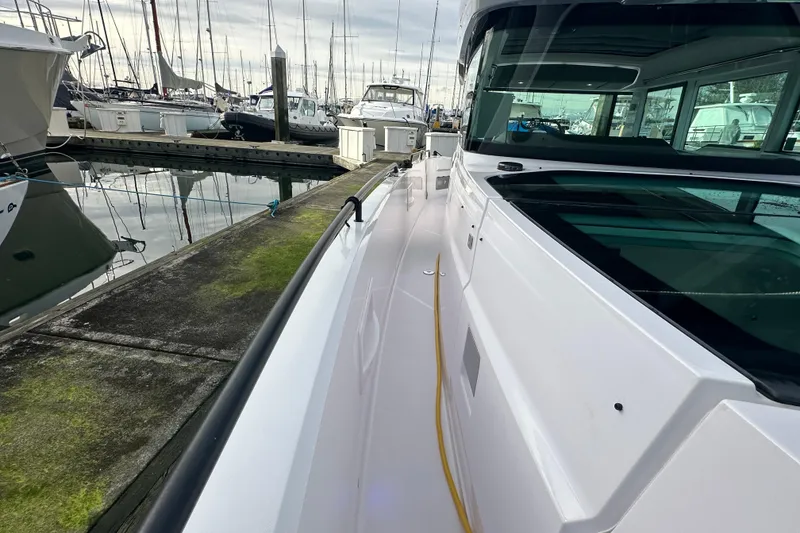 Slide: The Image of 2022 Axopar 37 XC Cross Cabin docked at marina, showcasing sleek design and modern features. - 18