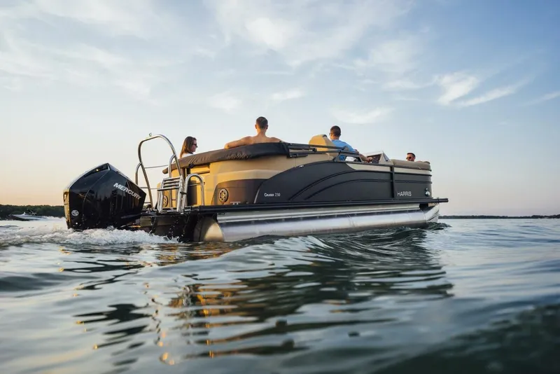 Slide: The Image of 2023 Harris Sunliner 230 Sport boat interior with plush seating and water view. - 12