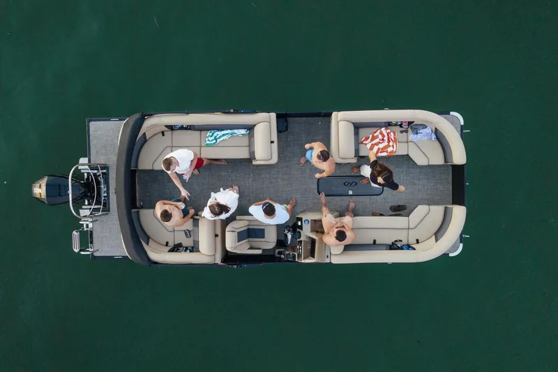 Slide: The Image of 2023 Harris Sunliner 230 Sport boat interior with luxurious seating on a serene waterway. - 14