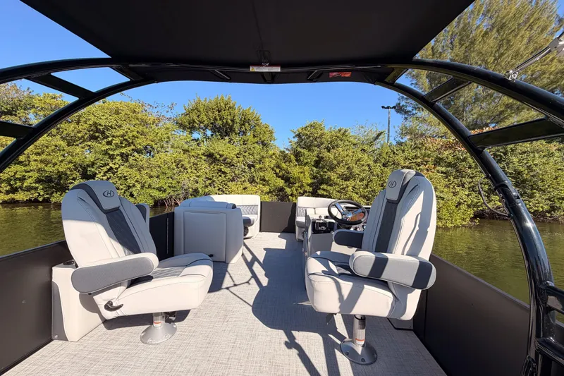 Slide: The Image of 2023 Harris Sunliner 230 Sport boat interior with plush seating and canopy. - 19