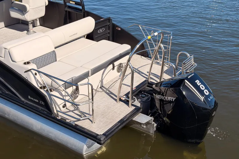Slide: The Image of 2023 Harris Sunliner 230 Sport pontoon boat with Mercury 200 V6 engine on water. - 25