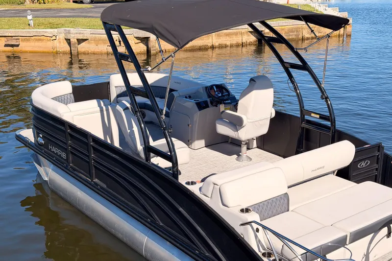 Slide: The Image of 2023 Harris Sunliner 230 Sport pontoon boat with canopy on calm water. - 26