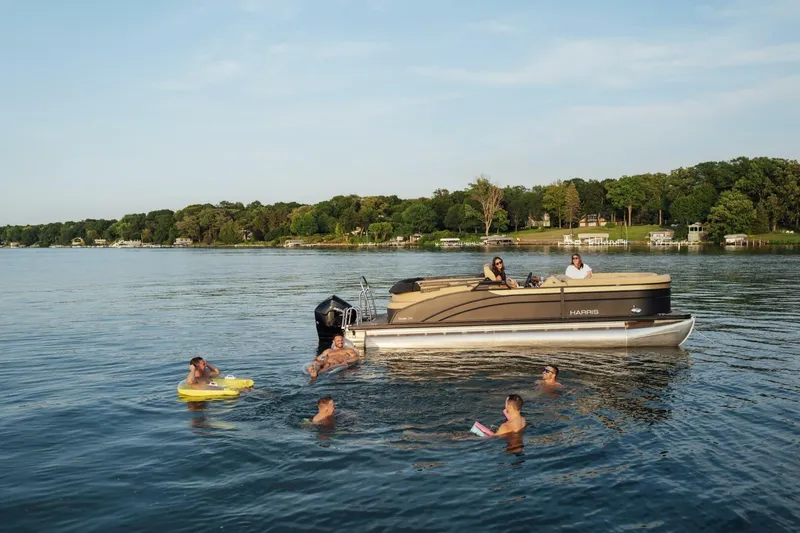 Slide: The Image of 2023 Harris Sunliner 230 Sport pontoon boat with luxurious seating and waterfront view. - 7