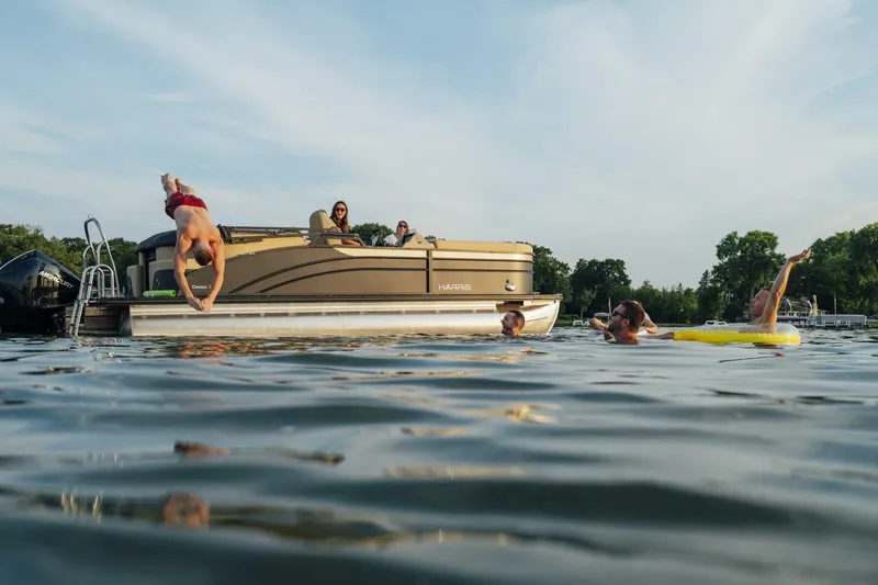 Slide: The Image of 2023 Harris Sunliner 230 Sport pontoon boat interior with luxurious seating and waterfront view. - 8