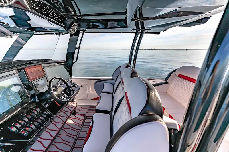 Slide: The Image of Manufacturer Provided Image: 2026 Sunsation 40 CCX boat interior with modern dashboard and luxurious seating on calm water. - 10