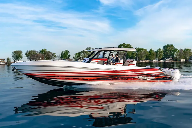 Slide: The Image of Manufacturer Provided Image: 2026 Sunsation 40 CCX speedboat cruising on a calm lake with vibrant red and white design. - 2