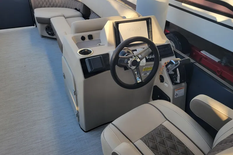 Slide: The Image of 2023 Harris Sunliner 250 Sport boat interior with steering wheel and seating. - 13