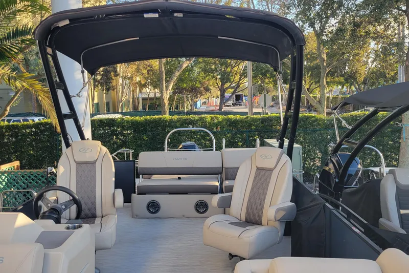 Slide: The Image of 2023 Harris Sunliner 250 Sport boat interior with plush seating and canopy. - 17
