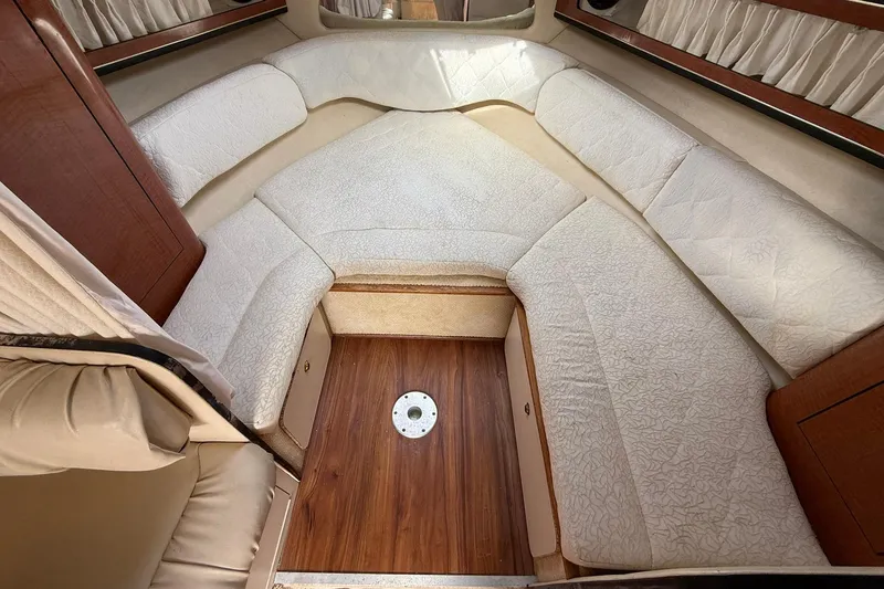 Slide: The Image of 2001 Sea Ray 280 Sundancer cabin interior with cushioned seating and wood flooring. - 10