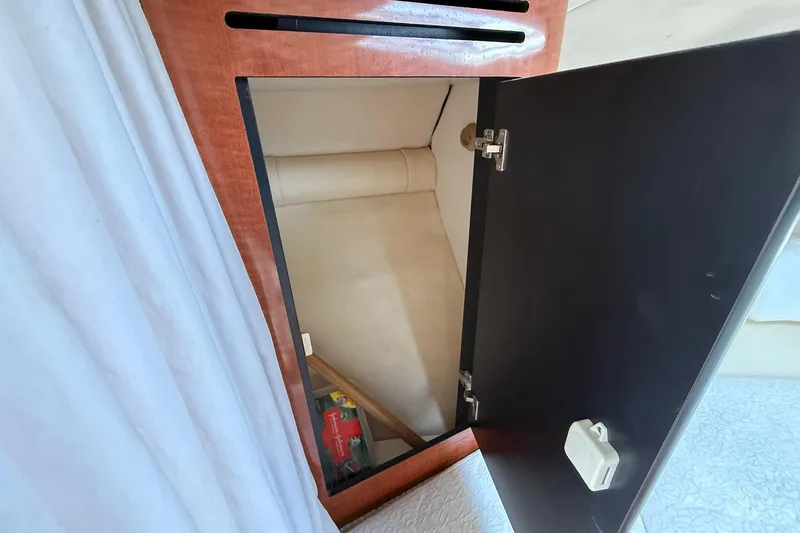 Slide: The Image of Open cabinet inside 2001 Sea Ray 280 Sundancer boat, showing interior storage space. - 11