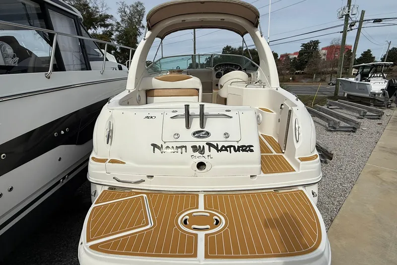Slide: The Image of 2001 Sea Ray 280 Sundancer boat with custom name, docked outdoors. - 2