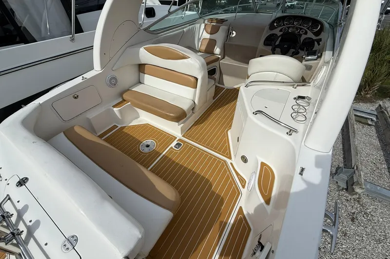 Slide: The Image of 2001 Sea Ray 280 Sundancer boat interior with tan seating and wood-style flooring. - 4