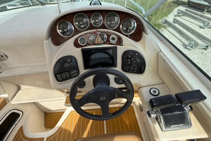 Slide: The Image of 2001 Sea Ray 280 Sundancer helm with steering wheel, gauges, and Mercury controls. - 9