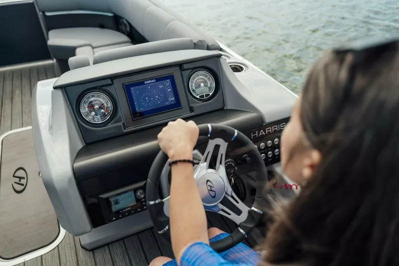 Slide: The Image of 2023 Harris Solstice 250 boat dashboard with steering wheel and navigation display. - 12