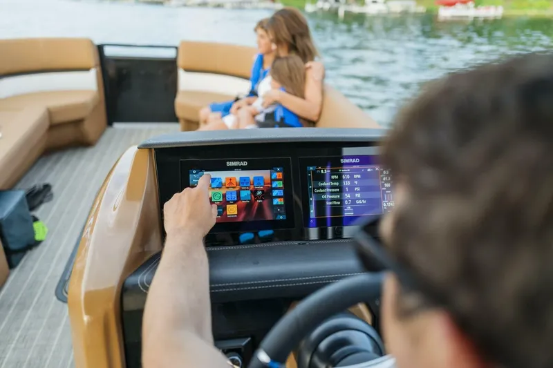Slide: The Image of 2023 Harris Solstice 250 boat dashboard with touchscreen controls, family enjoying the ride. - 13