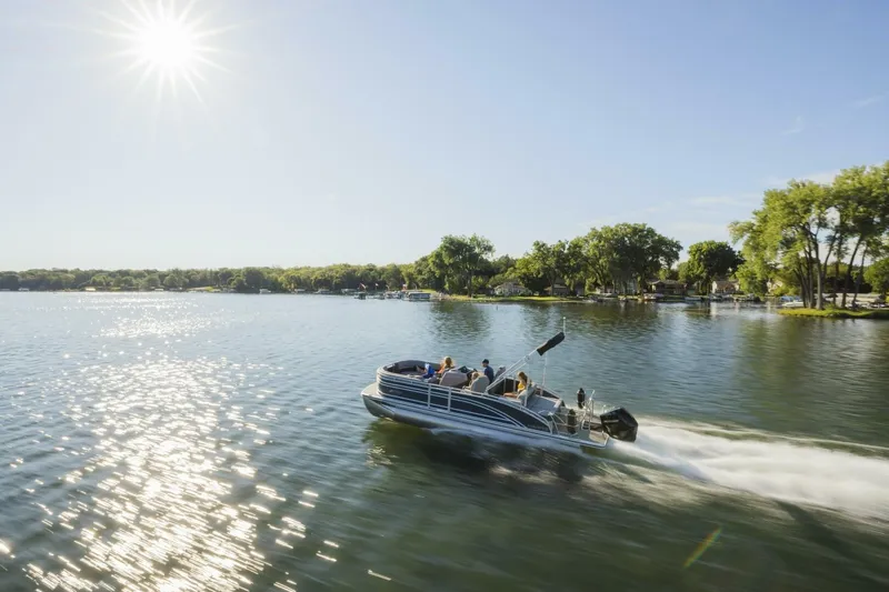 Slide: The Image of 2023 Harris Solstice 250 pontoon boat cruising on a sunny lake. - 3