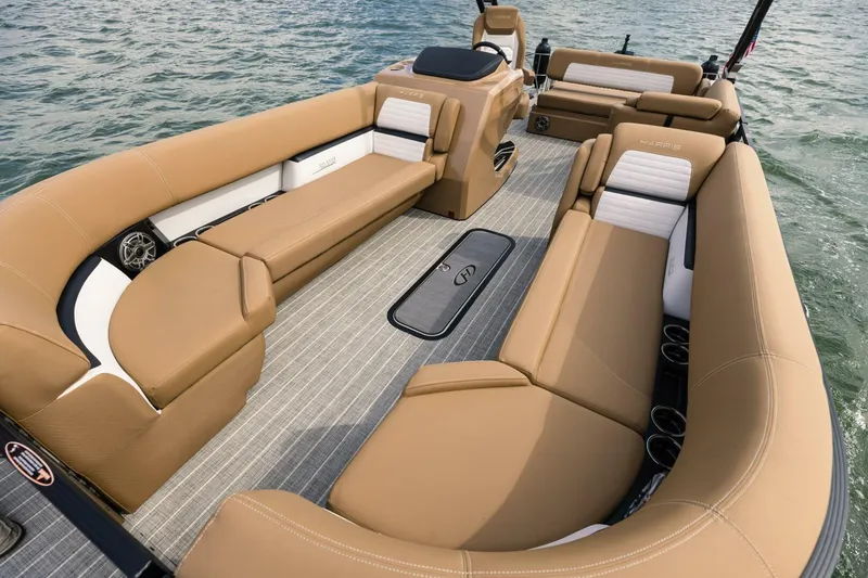 Slide: The Image of 2023 Harris Solstice 250 boat interior with tan seating and sleek design on water. - 9