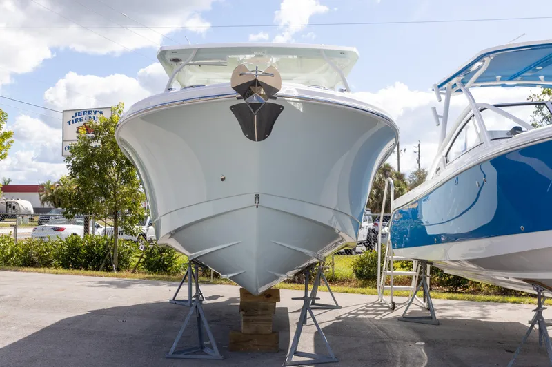 Slide: The Image of 2026 Edgewater 262CX Crossover boat on display, front view, sunny day. - 17
