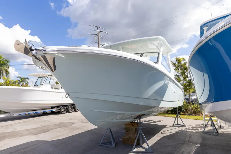 Slide: The Image of 2026 Edgewater 262CX Crossover boat displayed outdoors under a partly cloudy sky. - 9
