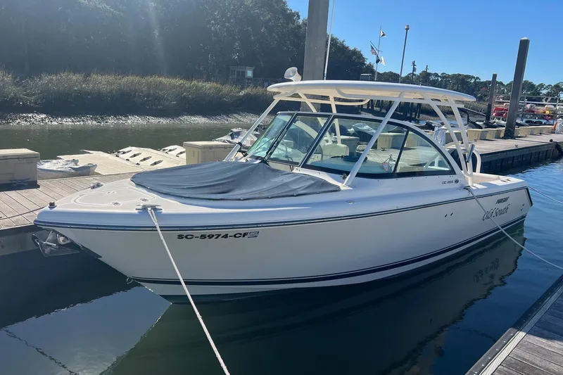 The Image of 2012 Pursuit DC 265 Dual Console boat docked at marina under clear sky. - 0