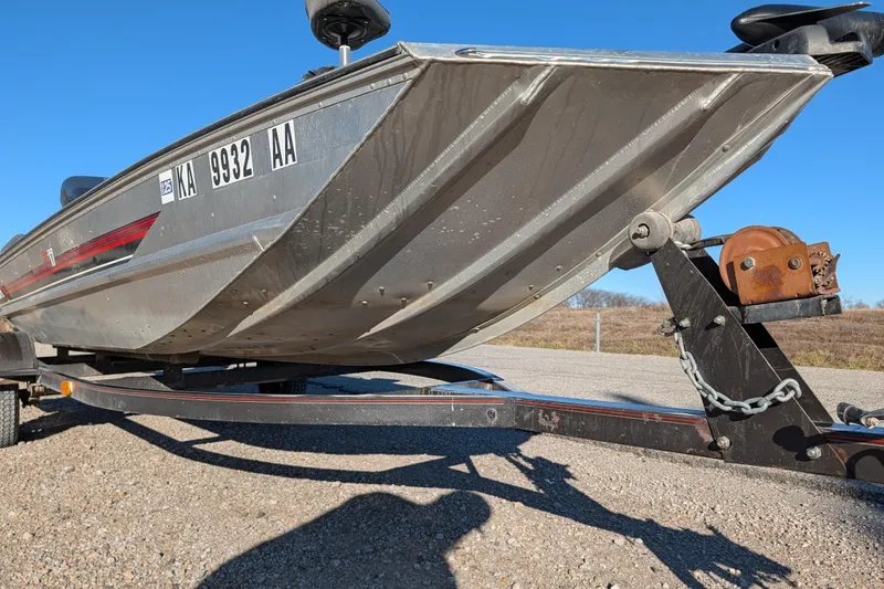 Slide: The Image of 1988 Bass Tracker Pro 17 boat on trailer, sunny day, gravel surface. - 10