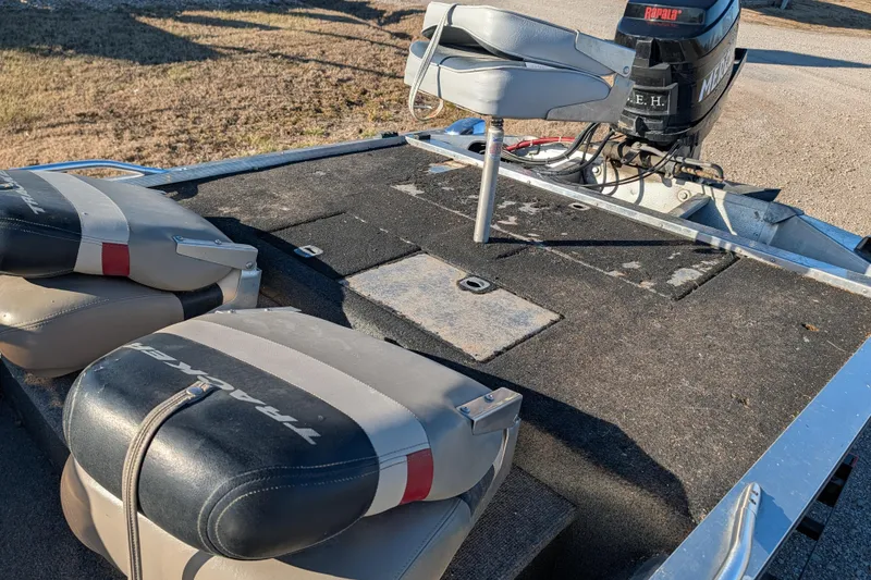 Slide: The Image of 1988 Bass Tracker Pro 17 boat interior with seats and motor, showing wear and outdoor setting. - 16