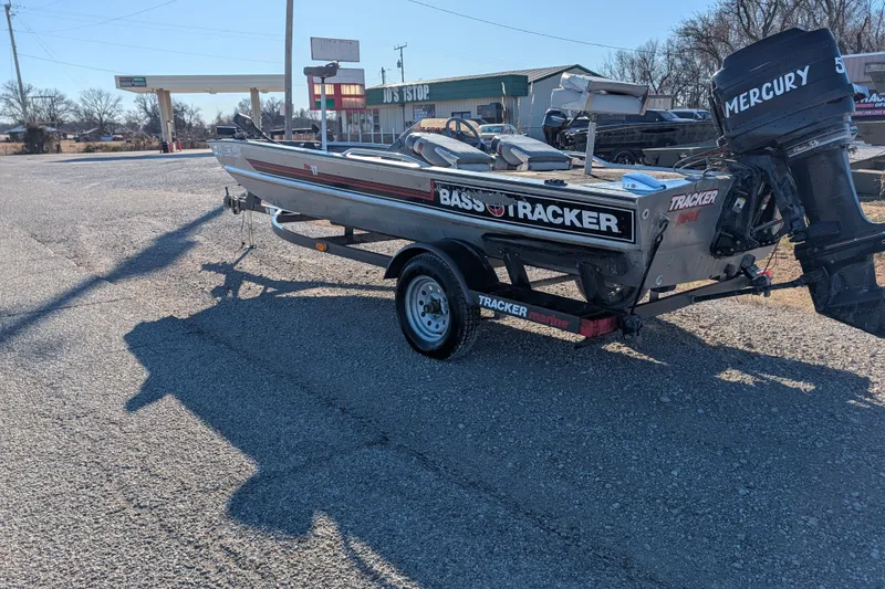 Slide: The Image of 1988 Bass Tracker Pro 17 boat with Mercury engine on trailer in parking lot. - 2