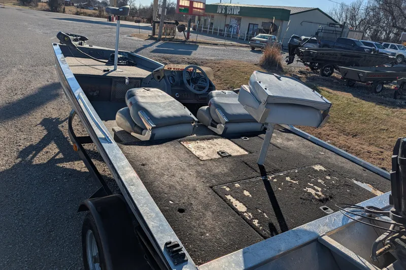 Slide: The Image of 1988 Bass Tracker Pro 17 boat with worn seats and steering wheel, parked outdoors. - 4