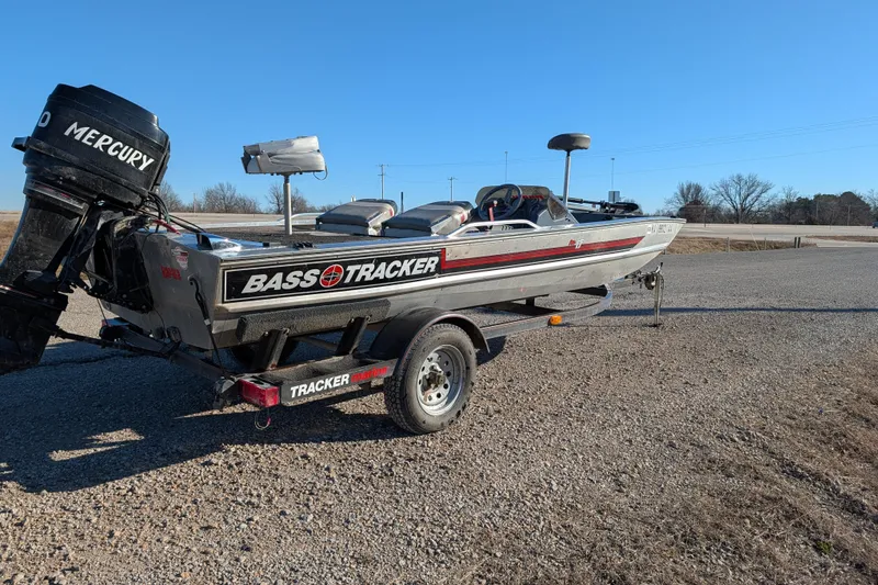 Slide: The Image of 1988 Bass Tracker Pro 17 boat with Mercury engine on a trailer, parked outdoors. - 7