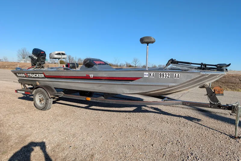 Slide: The Image of 1988 Bass Tracker Pro 17 boat on trailer, parked on gravel, clear blue sky background. - 9