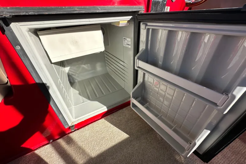 Slide: The Image of Open refrigerator inside a 2006 Duffy Cat 16 boat, showing empty shelves and compartments. - 10