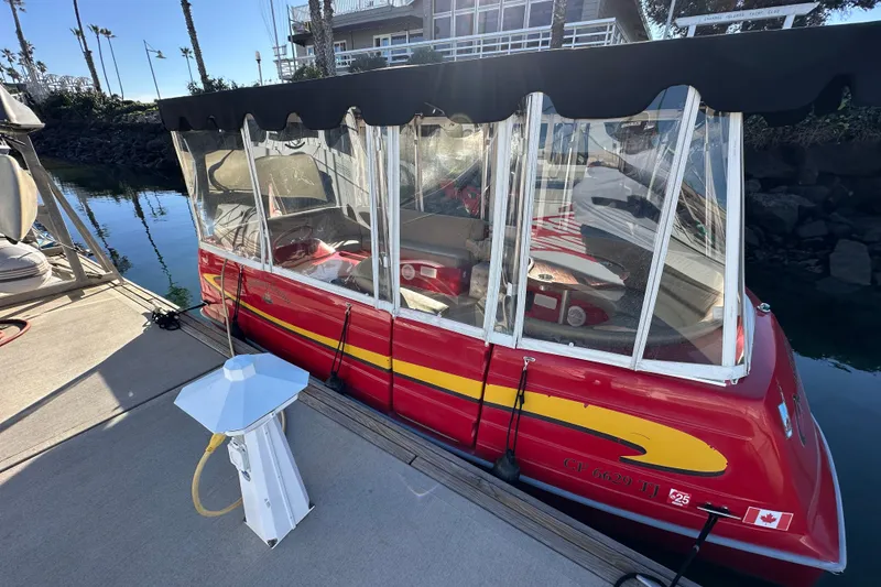 Slide: The Image of Red 2006 Duffy Cat 16 boat docked with clear canopy and Canadian flag. - 14
