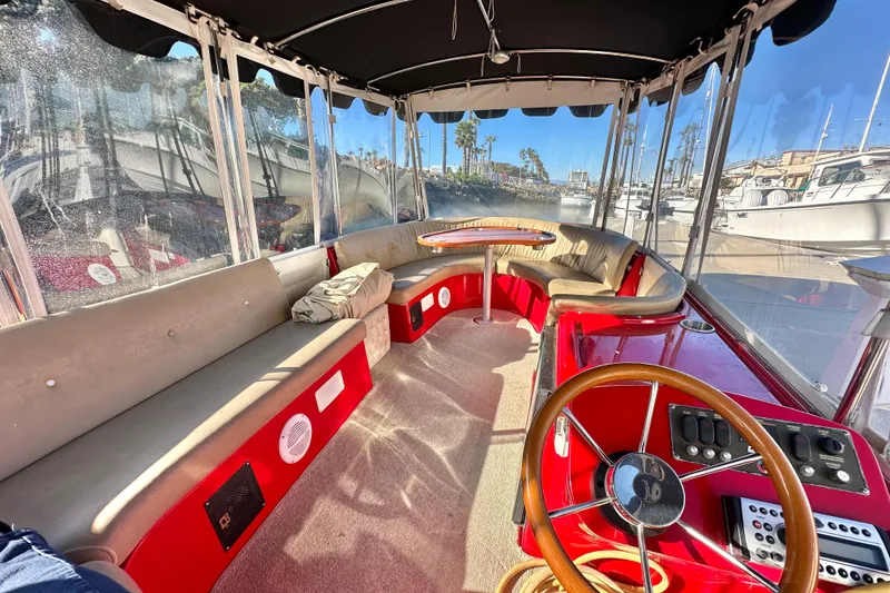 Slide: The Image of Interior of a 2006 Duffy Cat 16 boat with red seating and steering wheel. - 17