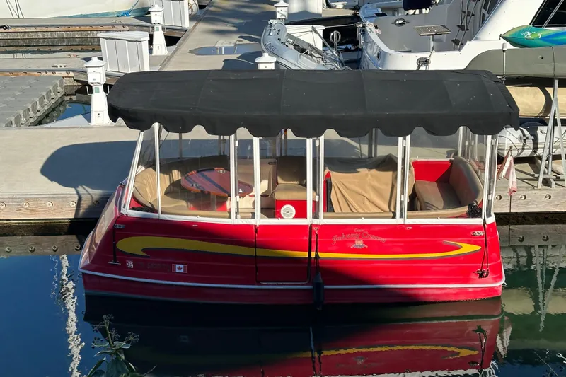 Slide: The Image of Red 2006 Duffy Cat 16 boat docked, featuring a black canopy and clear windows. - 20