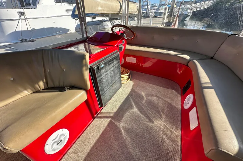 Slide: The Image of Interior of a 2006 Duffy Cat 16 boat with red accents and beige seating. - 3