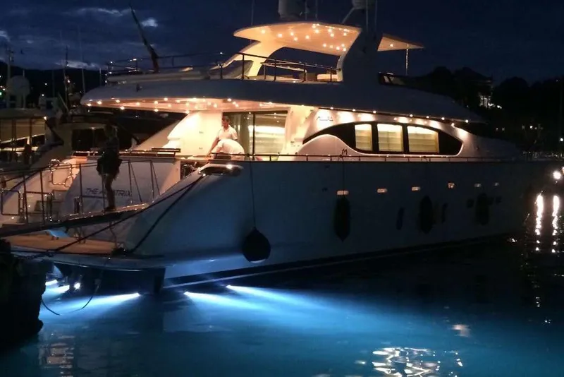 Slide: The Image of Luxurious 2012 Maiora yacht illuminated at night, docked with glowing underwater lights. - 2