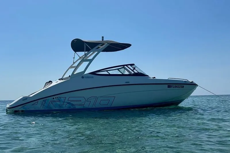The Image of 2021 Yamaha AR210 boat anchored on calm sea under clear blue sky. - 1