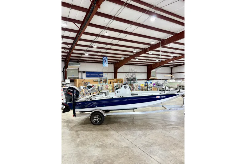 Slide: The Image of 2022 Express H20 Bay boat displayed indoors on a trailer. - 1