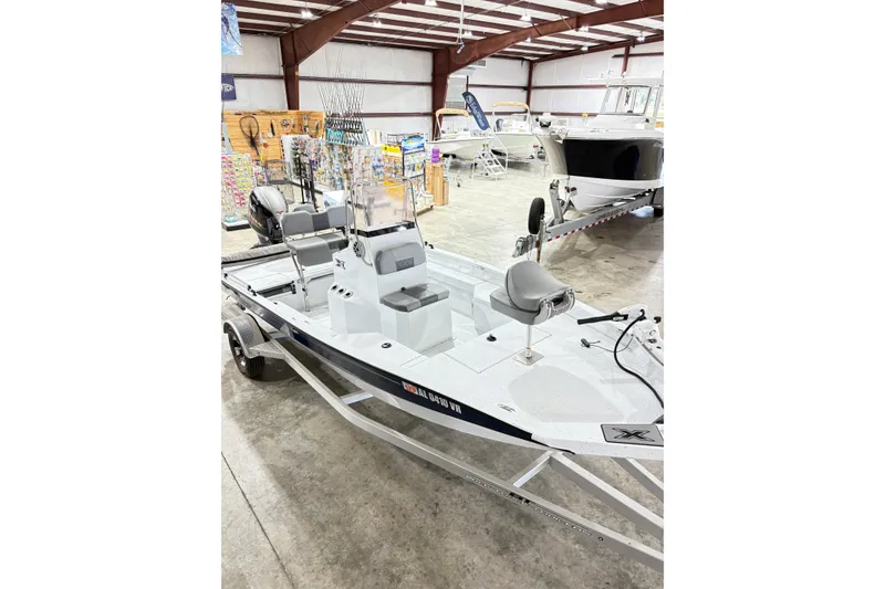 Slide: The Image of 2022 Express H20 Bay boat displayed in a showroom with fishing gear. - 13