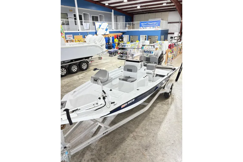Slide: The Image of 2022 Express H20 Bay boat displayed in a showroom with various marine accessories. - 16