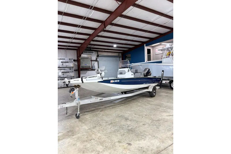 Slide: The Image of 2022 Express H20 Bay boat in a showroom, on a trailer, ready for display. - 2